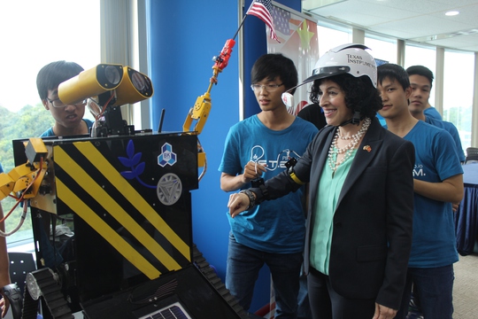 
Tổng Lãnh sự Mỹ tại TPHCM Rena Bitter đang thử điều khiển robot do các bạn trẻ Việt Nam trong CLB Robotics chế tạo. Ảnh: Thu Hằng
