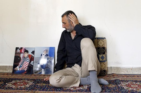 
Ông Ahmed Hadi Jawwad ngồi cạnh bức ảnh của hai đứa con

trong cuộc phỏng vấn hôm 11-9 ở Baghdad. Ảnh: REUTERS
