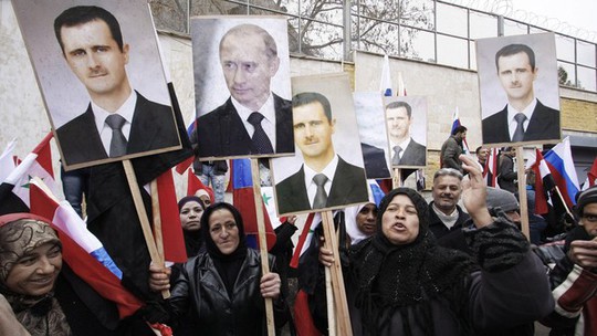 Những người biểu tình ủng hộ chính quyền Syria giơ cao hình ảnh của hai nhà lãnh đạo Bashar al-Assad và Vladimir Putin bên ngoài đại sứ quán Nga tại Damascus. Ảnh: AP
