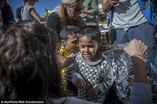 Một đứa bé khóc nấc sau khi được giải cứu. Ảnh: REUTERS
