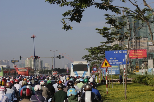 
Nút giao thông Xa lộ Hà Nội - Thảo Điền hướng về cầu Sài Gòn kẹt cứng. Xe bus bị bao quanh trong vòng vây xe máy.
