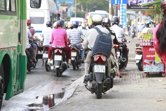 
Nhiều người chạy xe máy trên lề đường
