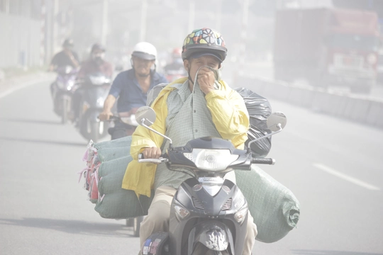 
Mù khô diễn ra nghiêm trọng, người dân Sài Gòn khốn đốn trong cơn bão bụi. Trong ảnh: Một thanh niên cố gắng che mặt để tránh khói bụi.

