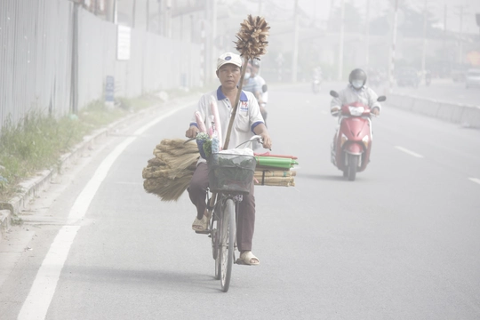 
Một người bán chổi mưu sinh đạp xe trên con đường đầy khói bụi gần cầu Sài Gòn (Q.2, TP.HCM)
