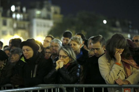 Người dân Paris cầu nguyện tại nhà thờ Đức Bà tối 15-11. Ảnh: Reuters