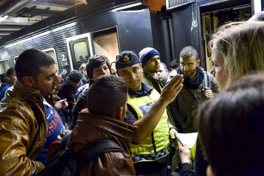 Cảnh sát Thụy Điển đang hướng dẫn người tị nạn. Ảnh: Reuters