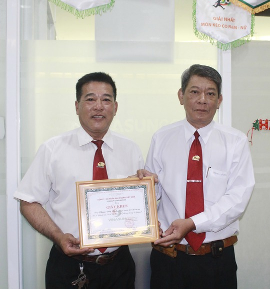 Đại diện Công ty Vinasun (bìa phải) trao giấy khen cho anh Phạm Văn Minh