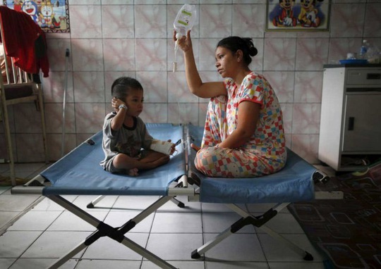 Một phụ nữ chăm sóc con trai mắc bệnh hô hấp do bụi mù tại tỉnh Trung Kalimantan - Indonesia Ảnh: Reuters