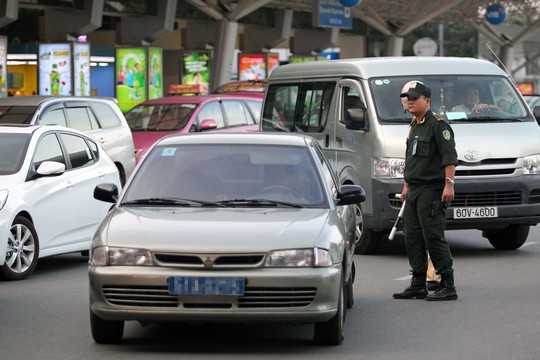 Lực lượng chức năng nhắc nhở các xe công dừng, đỗ không đúng quy định trong sân bay Tân Sơn Nhất chiều 23-11 Ảnh: HOÀNG TRIỀU