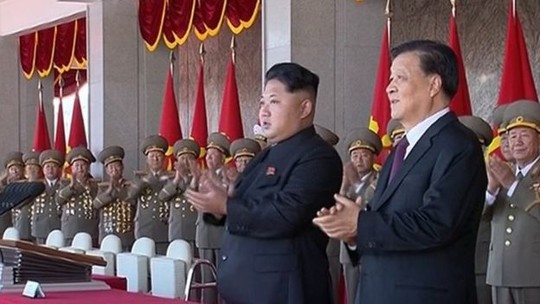 Nhà lãnh đạo Kim Jong-un và ông Lưu Vân Sơn (phải) trên bục danh dự. Ảnh: AP