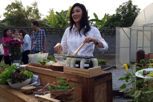 Bà Yingluck xắn tay áo làm món salad trộn cho cánh phóng viên khách mời hôm 8-1. Ảnh: Straits Times