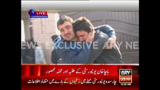 Phụ huynh ôm chặt con sau vụ thảm sát ở ĐH Bacha Khan. Ảnh: Reuters