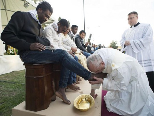 Giáo hoàng rửa và hôn chân người tị nạn. Ảnh: AP