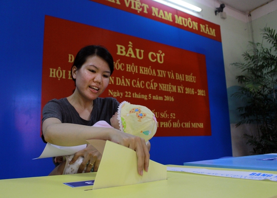 
Cử tri Nguyễn Thị Ngọc Ngân bồng theo con nhỏ hân hoan đi bỏ phiếu.
