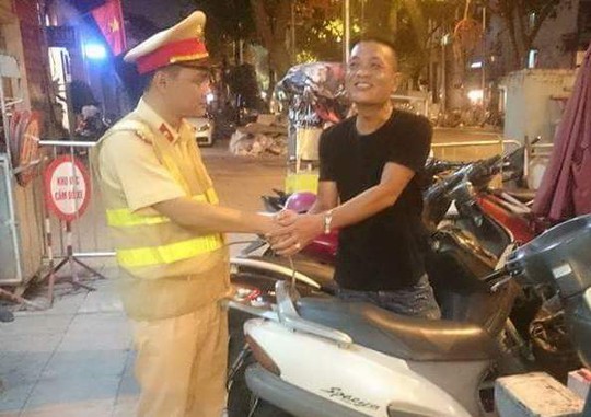 
Ông Nguyễn Hùng Anh bắt tay cảm ơn tổ công tác Y7/141 bên chiếc xe Honda Spacy kỷ vật của người vợ quá cố
