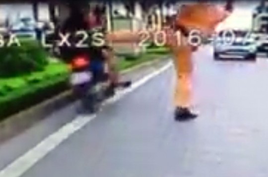 Cảnh được cho chiến sĩ CSGT giơ chân lên chặn người vi phạm giao thông - Ảnh: cắt từ clip