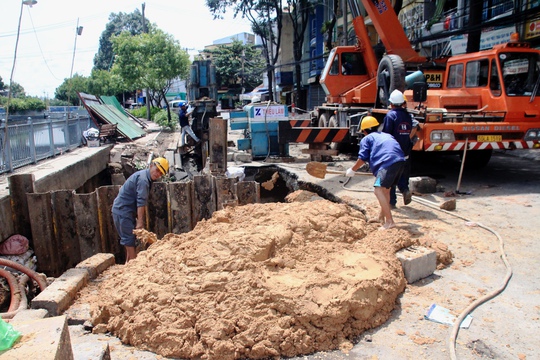 
Lòng hố có chiều sâu khoảng 5 m vẫn còn đọng nước, đang được công nhân lấp đất.
