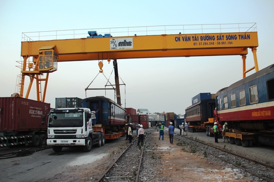 
Những xe cẩu lớn được huy động chuyển các toa tàu lên xe container
