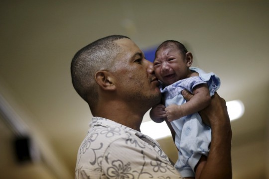 
Anh Geovane Silva bế cậu con trai Gustavo Henrique mắc dị tật đầu nhỏ nghi do virus Zika,

ở bệnh viên Oswaldo Cruz (Brazi). Ảnh: Reuters.

