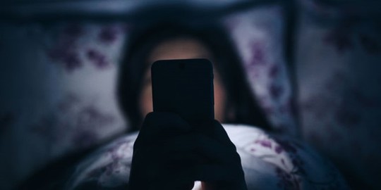 
Ôm điện thoại lên giường ngủ sẽ gây hại cho sức khoẻ. Ảnh: Getty.
