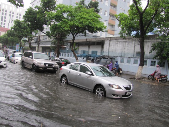 Nhiều xe ô tô nối đuôi dừng lại do nước phía trước trên đường Quang Trung dâng cao