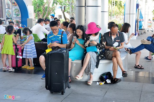 Du khách Trung Quốc ngồi vạ vật cùng hành lý. Ông Trần Sơn Hải - Phó chủ tịch UBND tỉnh Khánh Hòa xác nhận, sân bay Cam Ranh đang quá tải, trong khi đó cơ sở hạ tầng không đáp ứng được nhu cầu.