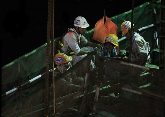 
Một nhóm công nhân tăng ca vào ban đêm đang bàn bạc công việc trước khi bắt tay vào làm việc tại dầm cầu Metro ở sông Sài Gòn.
