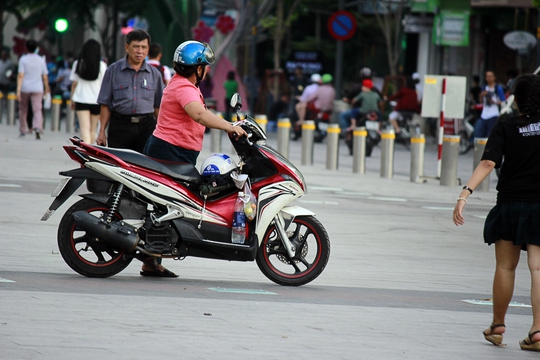 
Nhiều người dắt xe máy, thậm chí chạy xe máy ngang phố đi bộ Nguyễn Huệ bất chấp biển báo cấm.
