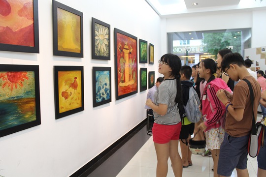 Các em học sinh thích thú xem tranh tại triển lãm. Ảnh Ngọc Lê