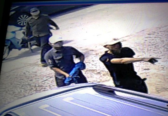 
Thanh niên đứng giữa cầm một khẩu súng giấu trong tấm vải màu xanh xông vào nhà ông Trịnh Ngọc Đỉnh (ảnh cắt từ camera)
