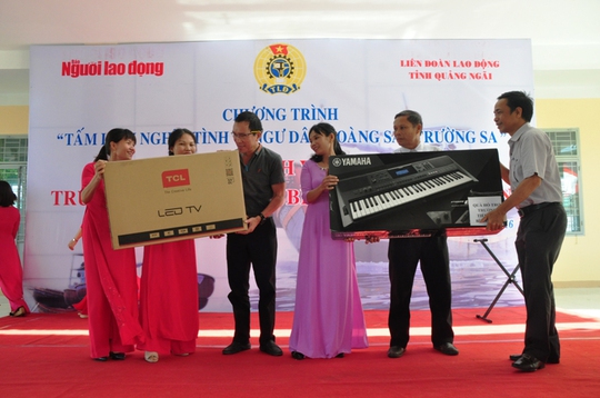 Đại diện Quỹ Tấm lòng vàng Người Lao Động và Công ty TNHH sản xuất Duy Lợi trao quà cho đại diện nhà trường