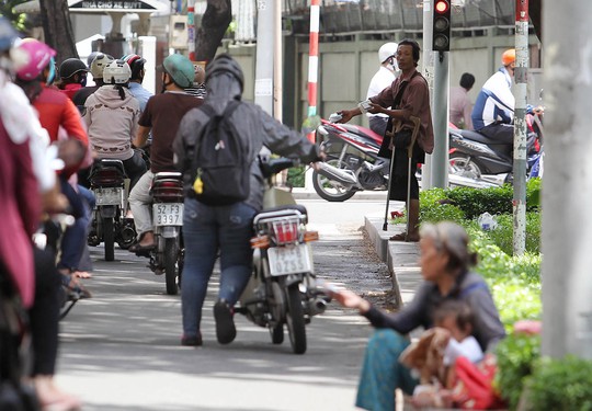 
Bà cụ và người đàn ông chống nạng đều chờ người đi đường mềm lòng, mua vé số
