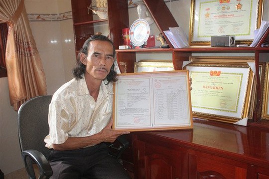 Anh Vũ Ngọc Báo, GĐ HTX Thạnh Hòa bên giấy chứng nhận sản xuất đạt chuẩn VietGAP của HTX