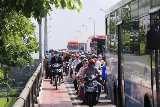 
Hàng trăm xe máy nối đuôi nhau leo 2 bên hành lang cầu Bình Triệu 2 để di chuyển
