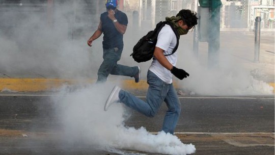 Người biểu tình đụng độ cảnh sát ở Caracas. Ảnh: REUTERS