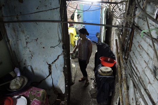 
Căn nhà nhỏ chưa tới 20m2 của nhà bà Nguyễn Thị Tuyết Mai (54 tuổi) thuộc diện xuống cấp, hư hỏng nặng nhất khu vực vì bên trong nhà có một cây cổ thụ hơn trăm tuổi mọc giữa nhà, ép sát tường tạo những vết nứt lớn, kéo dài.
