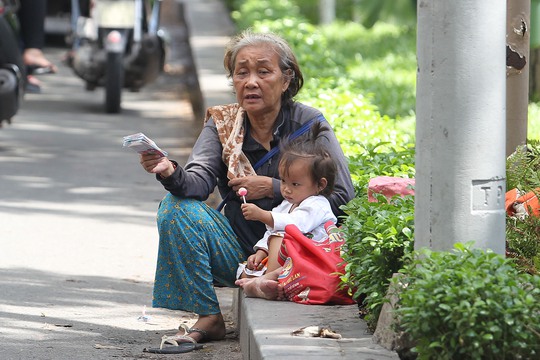 
Bà cụ này với xấp vé số trên tay dẫn theo một cháu bé khoảng 2 tuổi mưu sinh tại ngã tư Trương Định - Điện Biên Phủ
