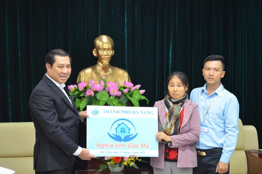 Chủ tịch UBND TP Đà Nẵng Huỳnh Đức Thơ trao biển tượng trưng căn hộ cho vợ con liệt sĩ Vũ Phi Trừ Ảnh: HIẾU THANH