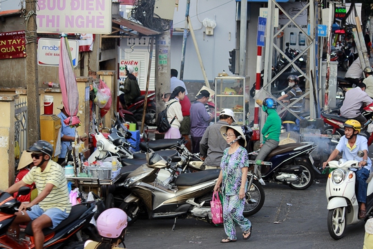 
Vỉa hè trước bưu điện Thị Nghè (quận 1) ngang nhiên bị trưng dụng buôn bán tấp nập, còn người đi bộ... đi giữa lòng đường.
