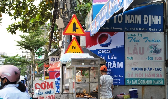
Biển báo giao thông chen lấn với biển quảng cáo trên đường Quốc Hương (quận 2)
