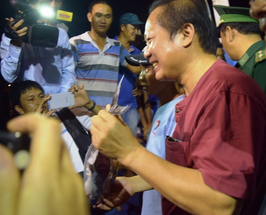 Bộ trưởng Trương Minh Tuấn vui vẻ khi bỏ tiền túi ra mua cá cho ngư dân - ảnh Hoàng Phúc