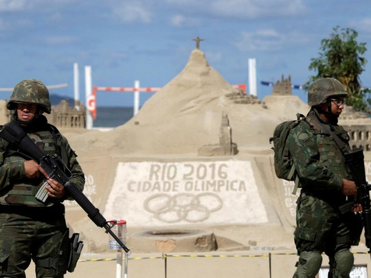 Binh sĩ Brazil tuần tra bãi biển Copacabana hôm 18-7. Ảnh: REUTERS