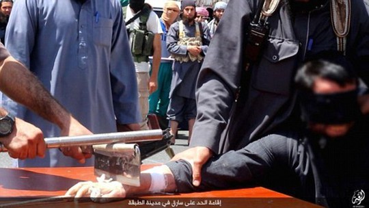 IS dùng một con dao to và thanh sắt để chặt tay phạm nhân. Ảnh: Daily Mail