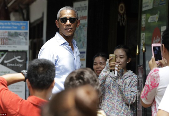 
Người Lào tranh thủ chụp hình Tổng thống Mỹ. Ảnh: AP
