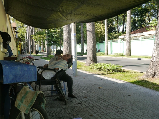 
Chậm rãi tận hưởng buổi trưa hè êm ả dưới đôi bàn tay khéo léo của người nghệ sĩ hớt tóc đường phố. Cho đến nay, chiếc ghế bạc màu đã cùng ông Đạt gắn bó với những gốc cây ngót nghét cả hai chục năm trời.
