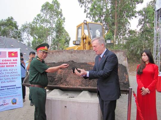 Thượng tướng Nguyễn Chí Vịnh và Đại sứ Hoa Kỳ Ted Osius, lấy tay cầm đất từng nhiễm dioxin đã qua xử lý.