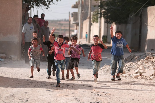 Trẻ em ở TP Manbij, tỉnh Aleppo - Syria vui mừng khi chiến sự sắp kết thúc. Ảnh: REUTERS