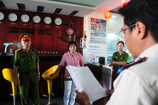 Lực lượng chức năng đọc quyết định cưỡng chế kê biên khách sạn Long Thành Ảnh: KỲ NAM