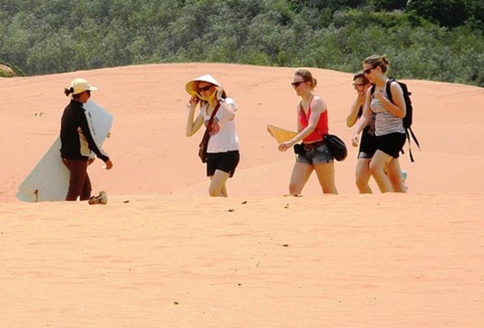 Dưới cái nắng đổ lửa, họ vẫn rảo bước mời khách du lịch trượt ván cát