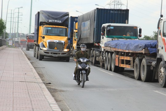 Nhiều tài xế container nóng lòng vào cảng đã lấn hẳn sang làn xe máy trên đường Vành đai 2 Ảnh: SỸ ĐÔNG